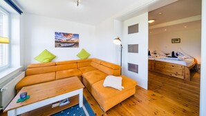 A modern living room with a sectional sofa, a wooden coffee table, and a painting on the wall.