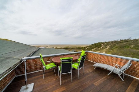 Speisen im Freien. Ferienwohnung 'Appartement Uitkieck' mit Meerblick, Gemeinschaftsterrasse und Wi-Fi