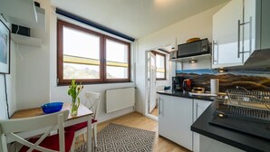 Een functionele keuken met een eethoek, een magnetron en uitzicht op de omgeving.