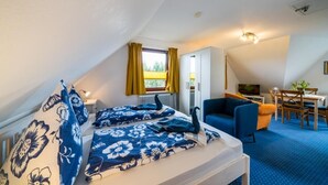 A bedroom with a bed, a desk, a chair, and a television. - Apartment 'Olde Toornblick' with Balcony and Wi-Fi (Borkum)