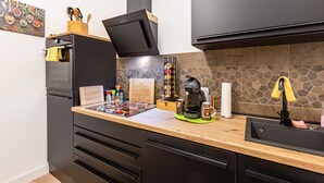 A kitchen with a microwave, coffee maker, and a wooden countertop.