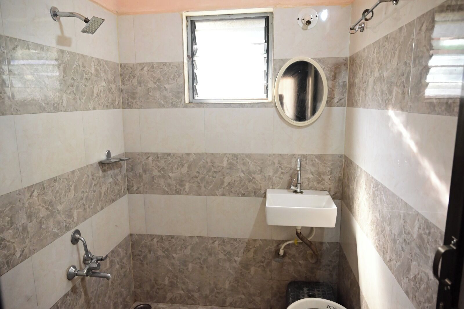 Een badkamer met een douche, wastafel en toilet.