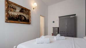 A hotel room with a bed, a painting, a wardrobe, and a door. - GuestHost - Modern Apartment 150m from Turro M1 (Milano)
