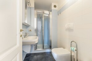 A bathroom with a shower, sink, toilet, and towel rack. - GuestHost - Charming 80 sqm apartment, for up to 8 people, located on the 4th floor of a building without a lift (40 steep steps at the entrance + 4 floors of stairs, not suitable for people with walking difficulties). The property is located in the hear (Firenze)