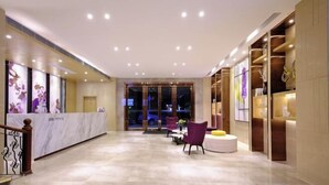 A hotel lobby with a reception desk, seating area, and a view of the street outside. - Lavande Hotel (Guangzhou Convention and Exhibition Center, Nanzhou Metro Station) (Guangzhou)