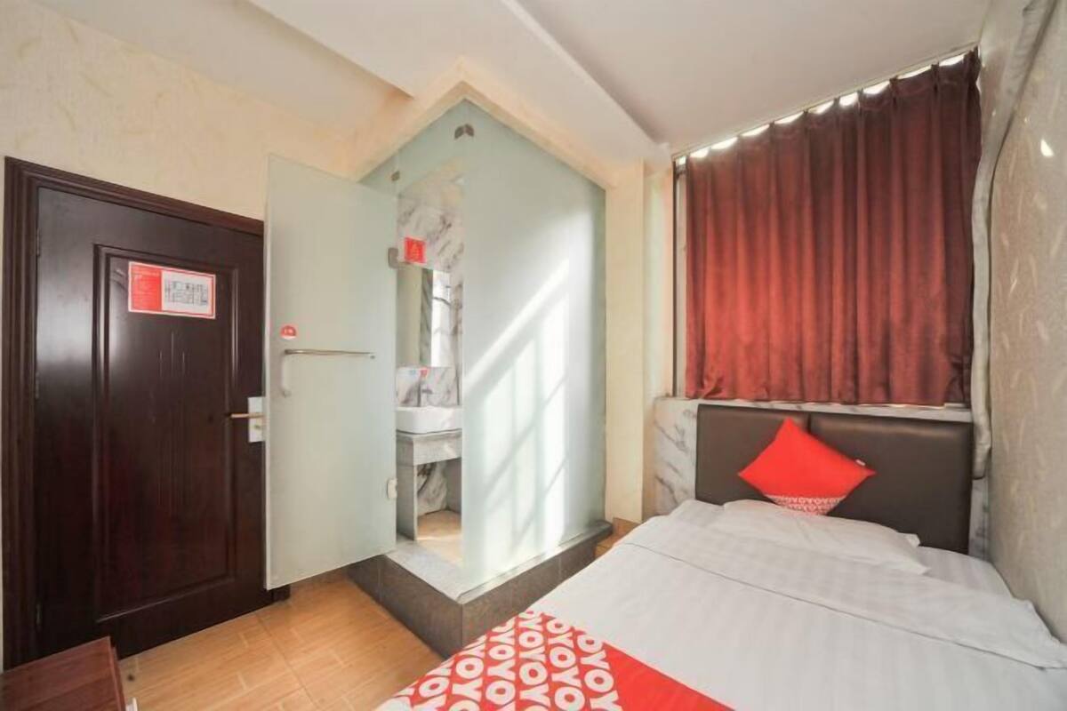 Une chambre d’hôtel avec un lit, une salle de bain et une porte avec une pancarte.