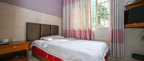 Quarto com cama, mesa de cabeceira de madeira e janela com cortinas.