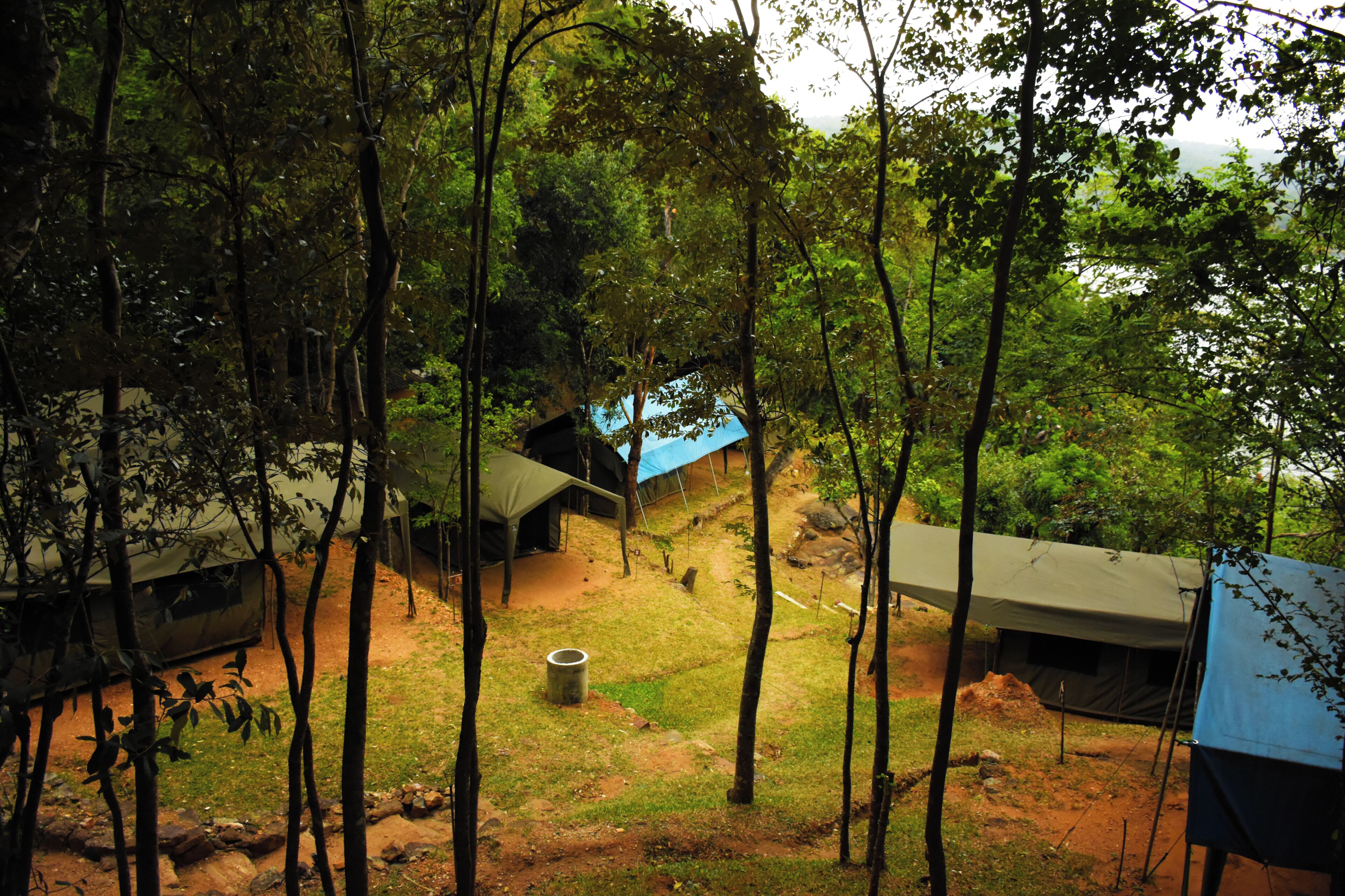 A campsite with multiple tents and a vehicle.