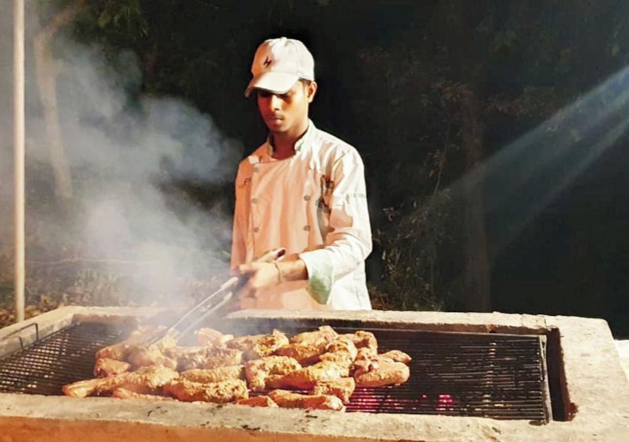 A person grilling meat outdoors.