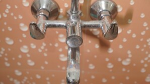 A bathroom with a showerhead and a wall with a floral pattern. - Hotel Inspira Residency- Near Bombay Hospital (Indore)