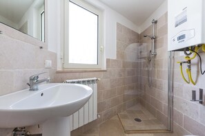Huis | Badkamer | Een douche, een haardroger, handdoeken