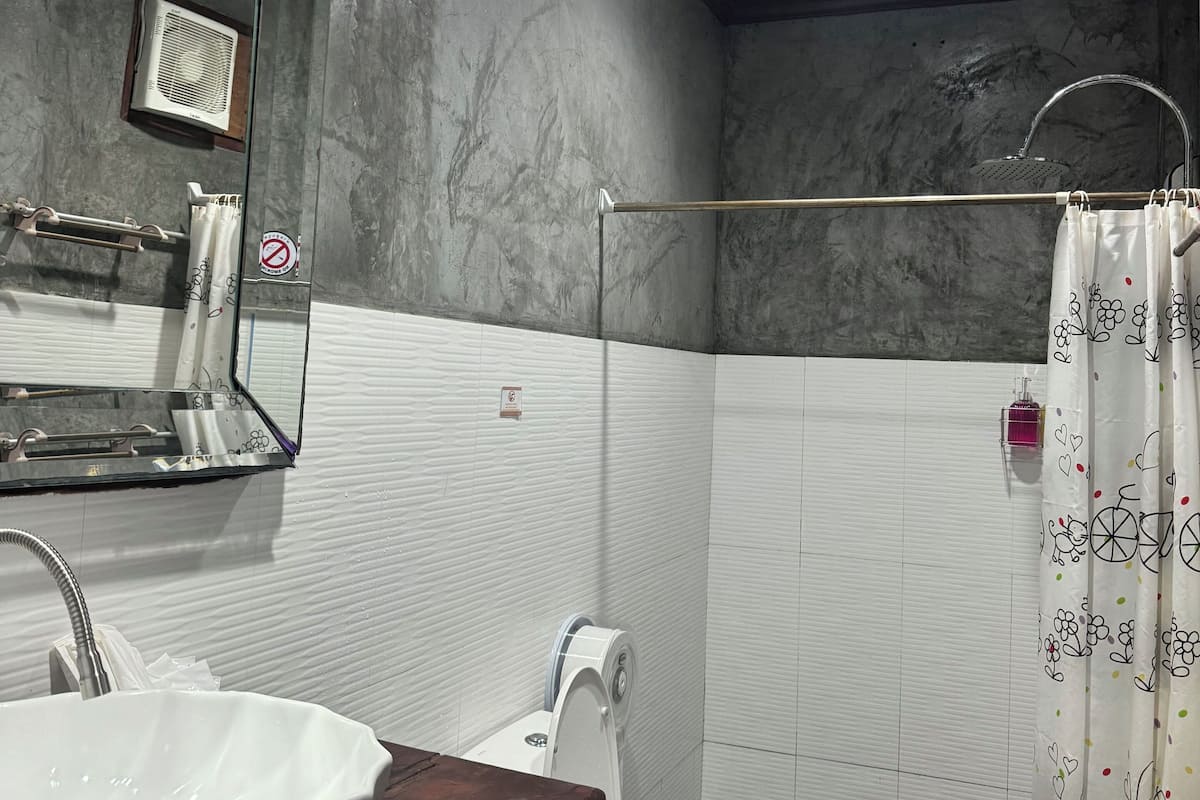 A bathroom with a white sink, a toilet, a shower with a glass door, and a mirror.