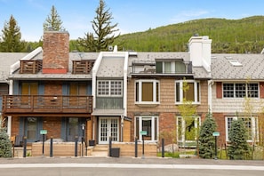 A row of townhouses with a shared driveway, wooden balconies, and a mountain backdrop. - Vail Village Condo - Short Walk to Village Center (Vail)