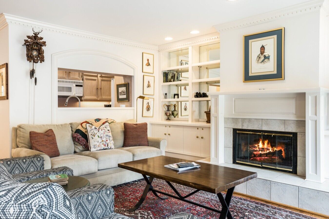 Una sala de estar con chimenea, un sofá, una mesa de centro y una estantería.