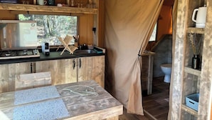 A compact kitchen with a stove, sink, and wooden cabinets.