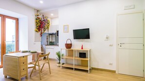 A modern, well-lit room with a wooden desk, chair, and a television mounted on the wall. - Lo Spagnoletto (Naples)