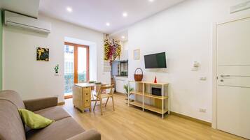 Apartamento conforto, 1 cama Queen e sofá-cama, para não fumantes, sacada | Área de estar | TV de tela plana