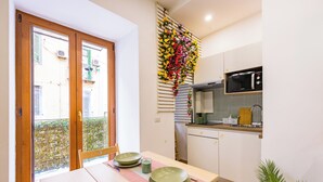 A compact kitchen with a microwave, a small sink, and a window overlooking a balcony. - Lo Spagnoletto (Naples)