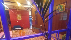 Une pièce avec un plancher en bois, un canapé bleu, une petite table et une plante en pot.