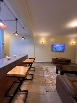 Family Apartment, Balcony, City View | Living area | 24-inch Smart TV with digital channels - Lux Suites Kipande Family Apartments (Nairobi)