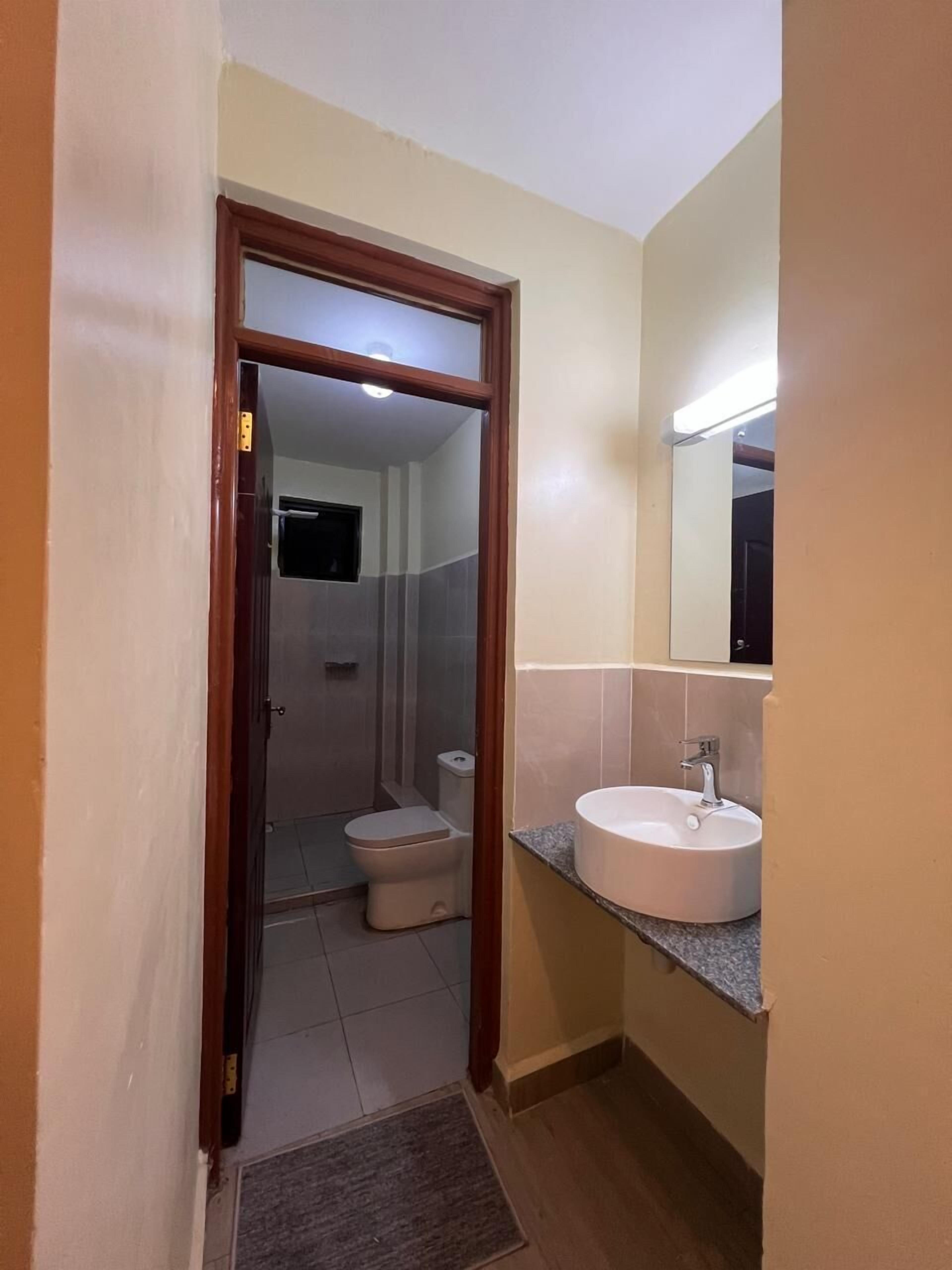 A bathroom with a toilet, sink, and shower.