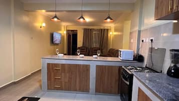 Family Apartment, Balcony, City View | Private kitchen | Fridge, microwave, cookware/dishes/utensils, dining tables