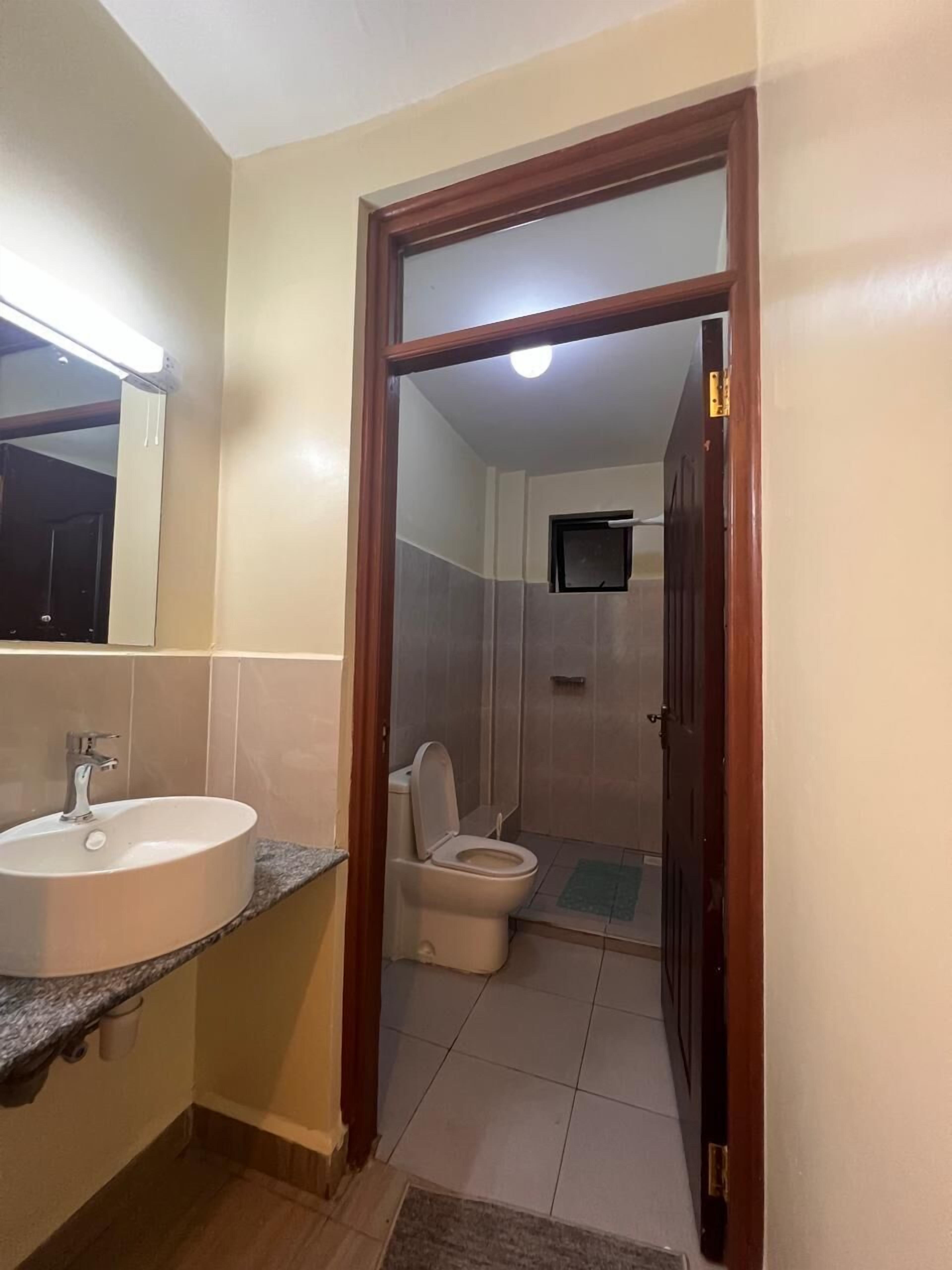 A bathroom with a sink, toilet, and shower.