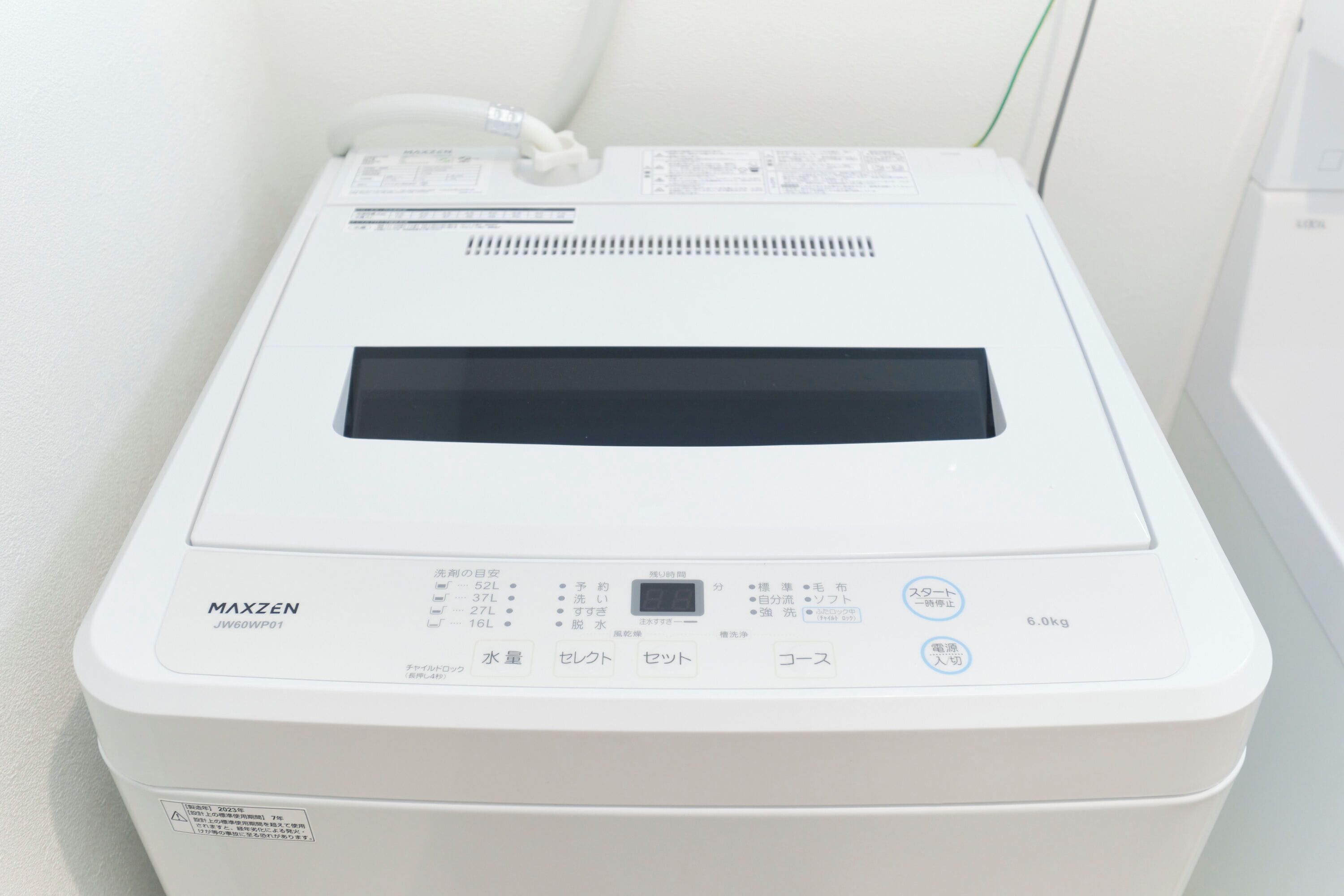 A white, compact, portable device with a digital display, buttons, and a label reading 'MAXZEN JW60WP01'.