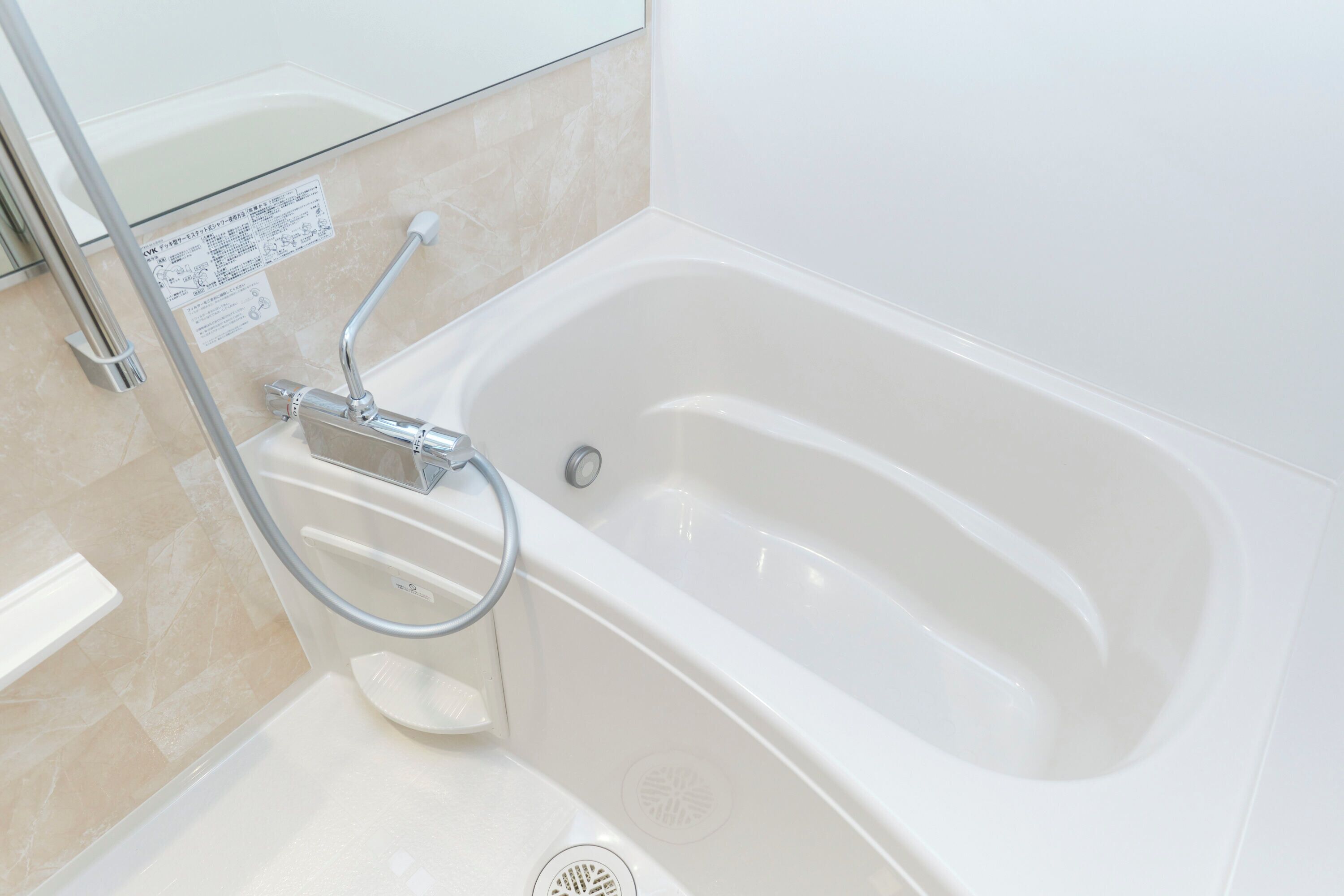 Ein modernes Badezimmer mit Badewanne, einer Duschkabine aus Glas und einer Handstange.
