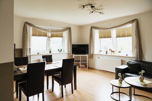 Relax in this open-plan living area with a dining table, sofa, and flat-screen TV.