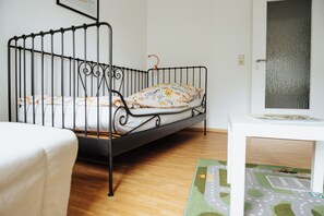 Cozy retreat with a metal-framed bed, small table, and a unique rug.
