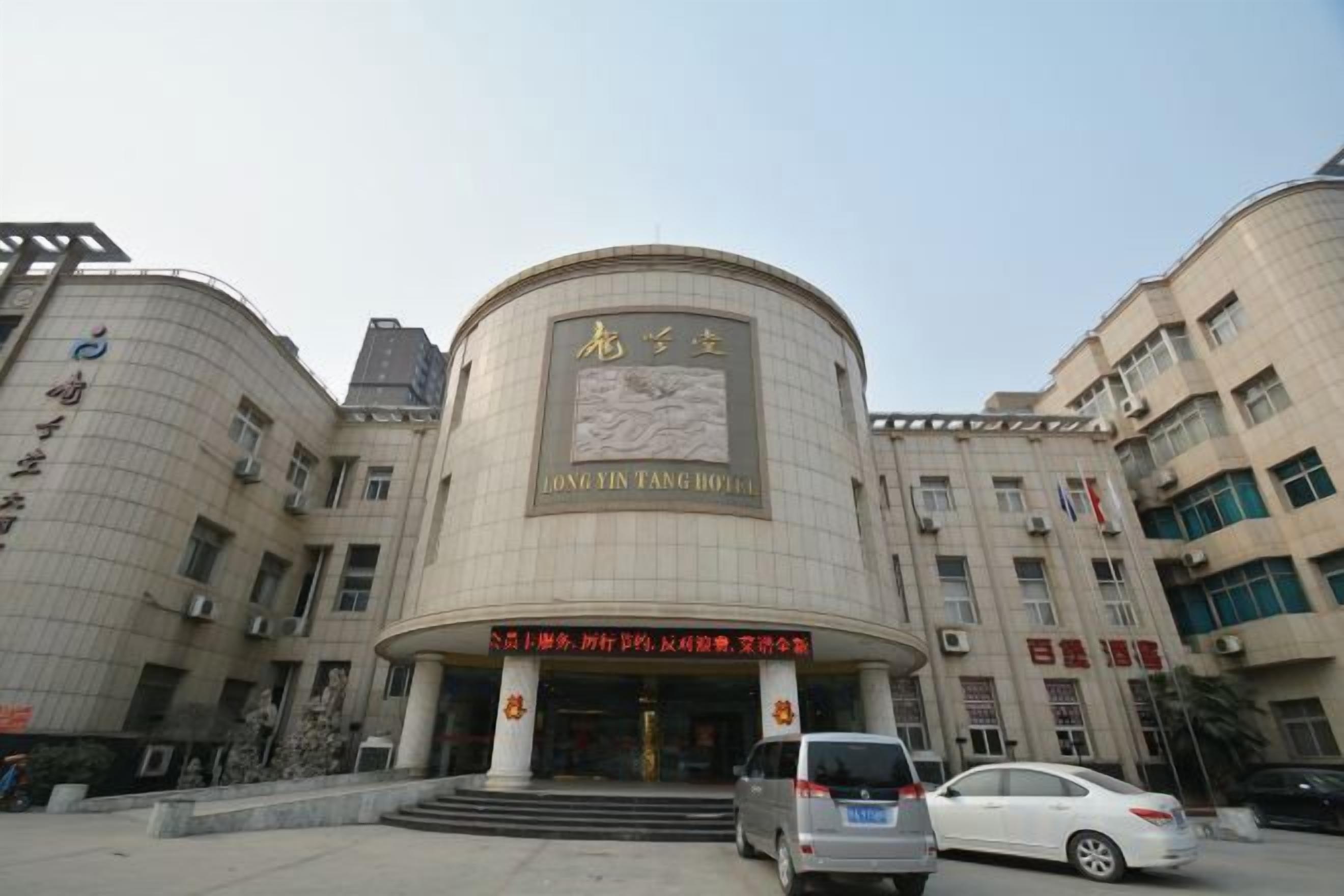 A hotel with a curved facade, a prominent entrance, and multiple floors.