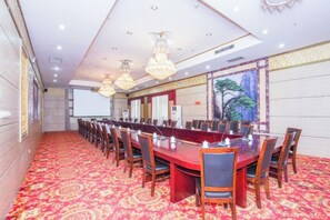Ein Konferenzraum mit einem langen Tisch, Stühlen und einem Teppichboden.