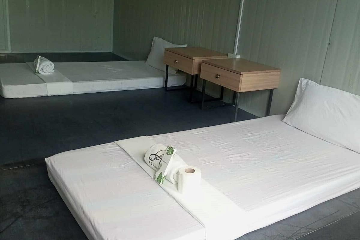 A hotel room with a single bed, a small desk with drawers, and a sofa.