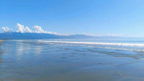 A beach with a clear sky and distant mountains. - The Waves at Socorro Baler- Hotel A (Baler)
