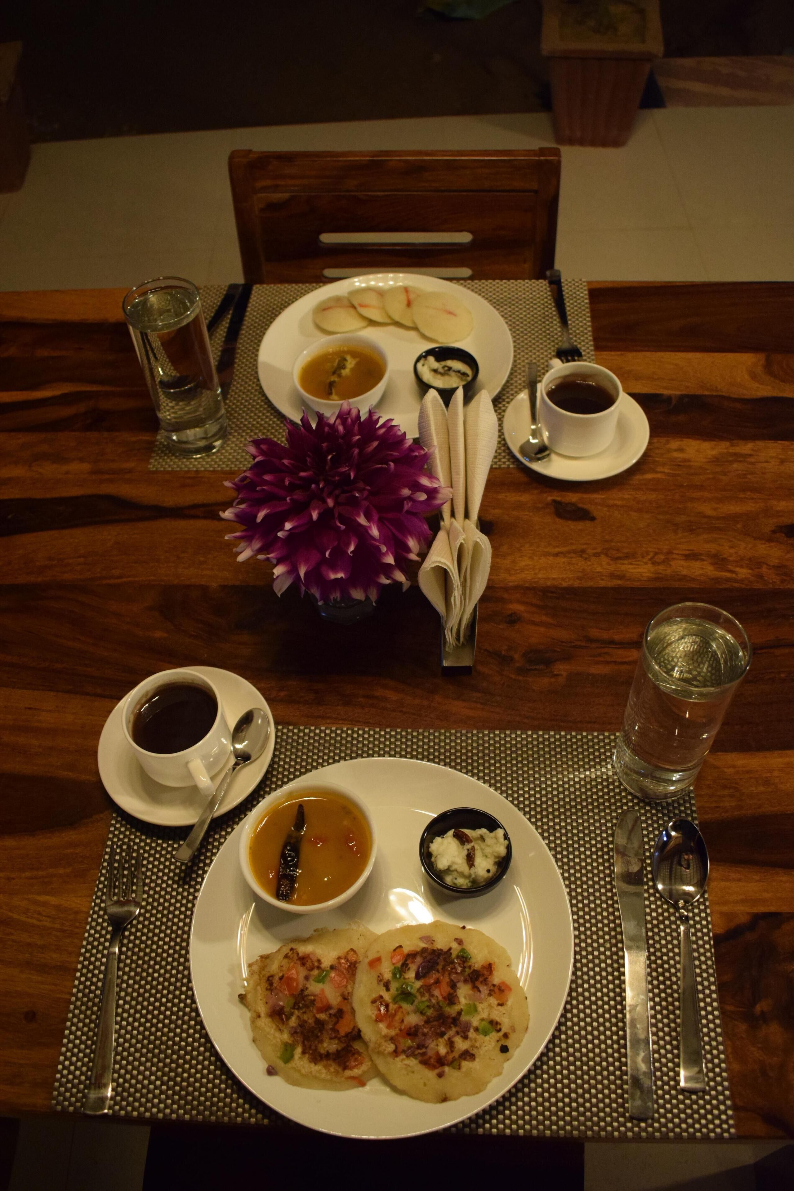 Een eettafel gedekt met borden eten, bekers en bestek.