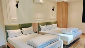 A hotel room with two beds, a wardrobe, and an air conditioning unit. - Rajasthani Hotel Dhani (Sonapur)