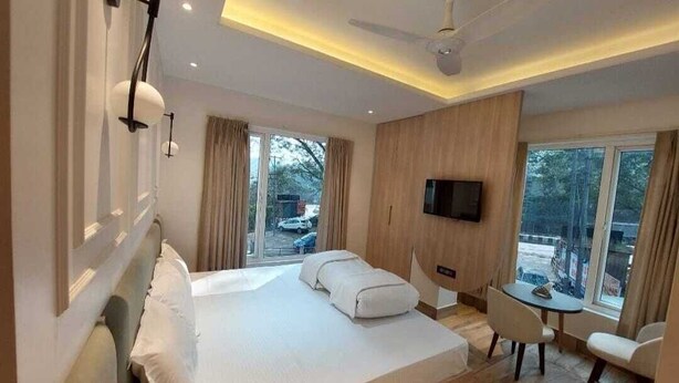 A modern hotel room with a large bed, a desk, and a TV. - Rajasthani Hotel Dhani (Sonapur)