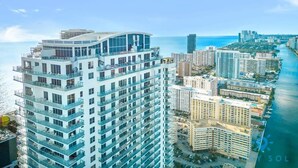 A high-rise hotel with multiple balconies, a waterfront view, and a cityscape in the background. - 3 BR Apartment with amazing View,  Pool and  Gym (Hollywood)