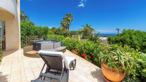 A patio with outdoor furniture, a hot tub, and a view of the sea. - 4046 Villa Del Vecchio by Barbarhouse (Ostuni)