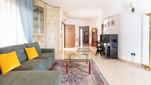 A living room with a sofa, coffee table, and a piano. - 4046 Villa Del Vecchio by Barbarhouse (Ostuni)