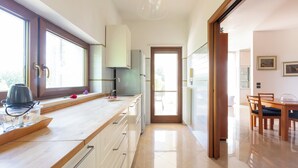 A modern kitchen with a wooden countertop, built-in cabinets, and a view to the dining area. - 4046 Villa Del Vecchio by Barbarhouse (Ostuni)