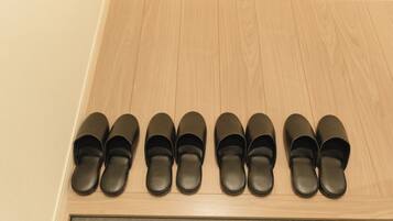 A wooden shoe rack with black shoes.