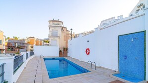 Ein Pool auf dem Dach mit freiem Blick auf die umliegenden Gebäude und einem Rettungsring an der Wand.
