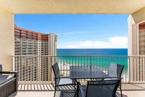 A balcony with a view of the ocean and a beach, featuring a table and chairs. - Shores of Panama Chic 2-BD Beachfront Resort Condo! (Panama City Beach)