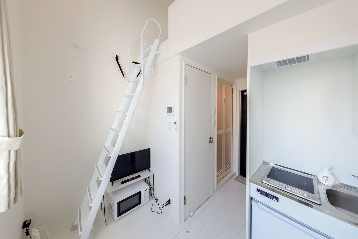 A modern kitchen with a built-in stove, microwave, and a white countertop.