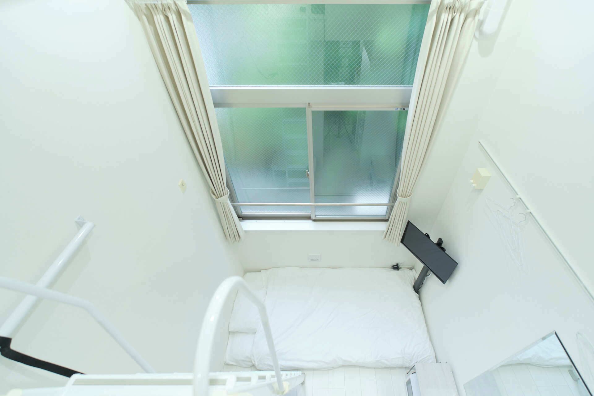 Une chambre d’hôpital avec une fenêtre, un lit et un lit médical.