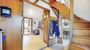Ein geräumiger Flur mit einer Holztreppe, einem Essbereich mit Tisch und Stühlen sowie einer Küchenzeile mit Spüle und Arbeitsplatte.