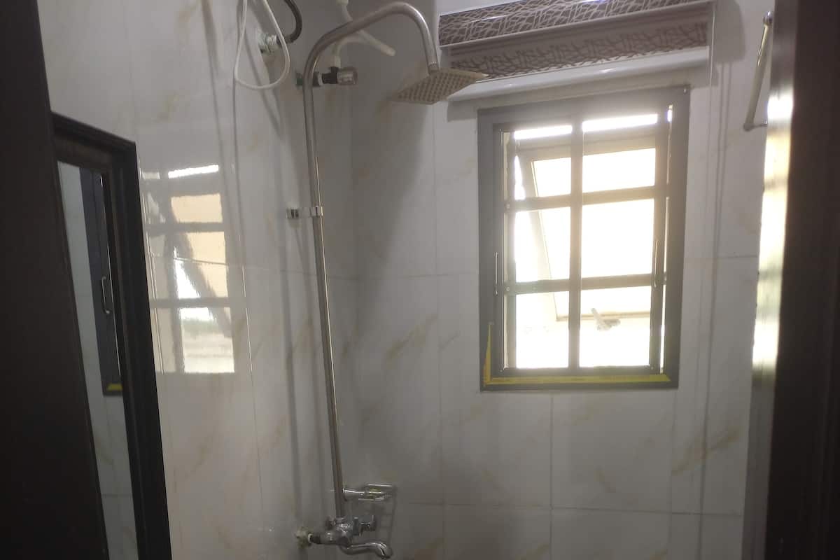 A bathroom with a shower, a toilet, and a sink.