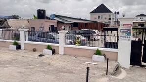 A construction site with a fenced area, a water tank, and a building under construction. - Tristar Hotel & Suites  (Lekki)
